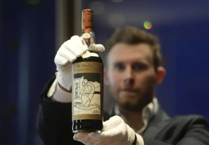 Ręce w białych rękawiczkach prezentują butelkę Macallan 1926. Czy to rekordowe jakie są najdroższe butelki whisky świata aukcyjne 2026?
