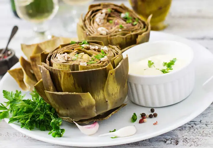 Artichauts entiers, tendres et savoureux, prêts pour la cuisson vapeur. Servis avec une sauce crémeuse et des herbes fraîches.