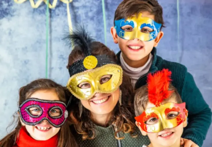 Familia sonriente con máscaras coloridas, celebrando lo que representa el carnaval.