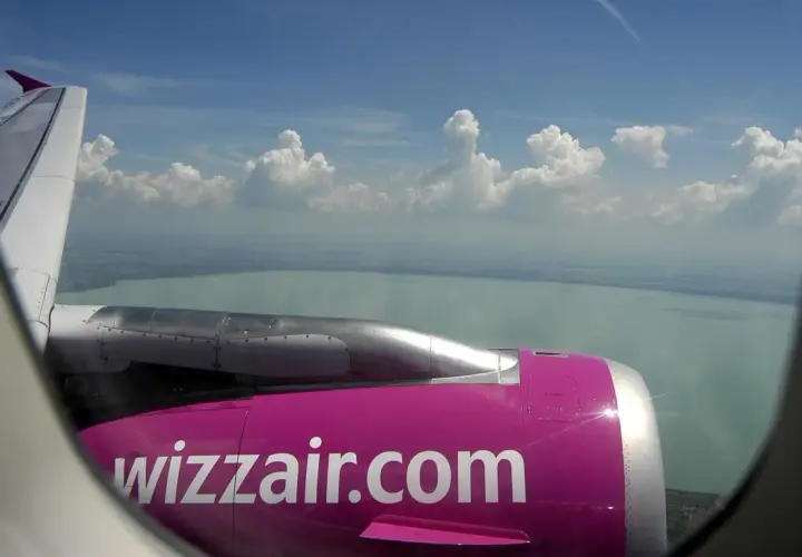 Widok z okna samolotu Wizzair na jezioro i chmury. Zastanawiasz się, ile kosztuje wybór miejsca w Wizzair?