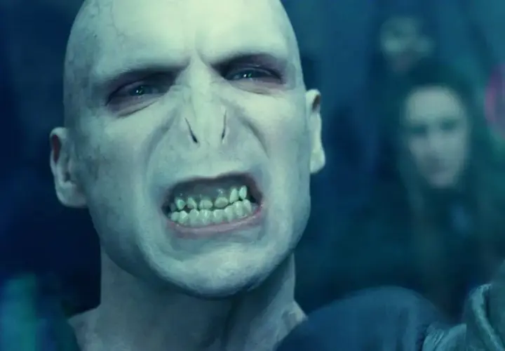 Złowrogi Lord Voldemort, którego grał Ralph Fiennes, z groźnym wyrazem twarzy i zielonymi oczami.