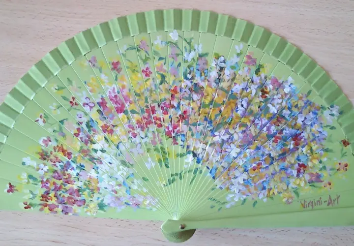 Abanico verde claro pintado con flores de muchos colores. ¡Perfecto para inspirar dibujos fáciles para pintar abanicos!
