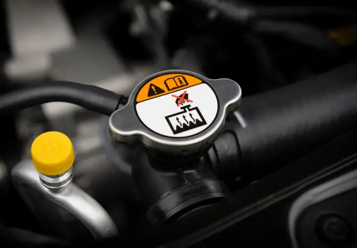 Tapa del radiador con advertencias. Es normal que un coche consuma anticongelante, pero revisa el nivel.