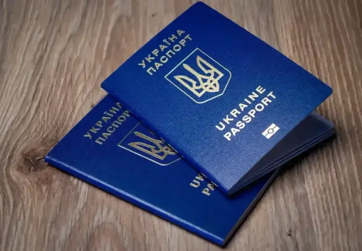 Dwa niebieskie paszporty Ukrainy leżą na drewnianym blacie. Czy wystarczy paszport, czy potrzebny jest dowód na wyjazd do Turcji?