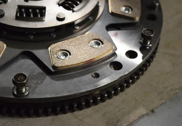 Metalowe elementy sprzęgła w automacie, z widocznymi okładzinami ciernymi i zębatym wieńcem.