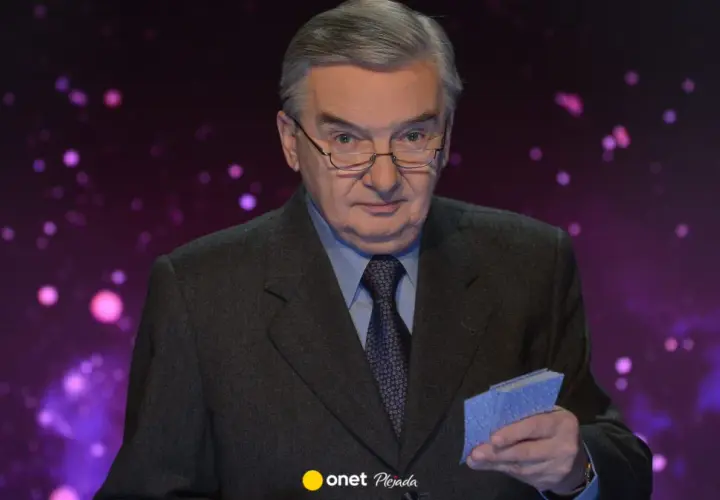 Tadeusz Sznuk w garniturze, z okularami na nosie, trzyma w dłoni małe niebieskie karty. Może to być nawiązanie do jego żony, która kiedyś grała w karty.