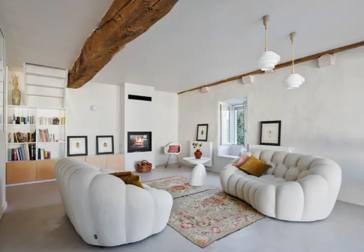 Salon cosy avec cheminée et canapés arrondis. La ventilation appartement est discrète, intégrée au design moderne.