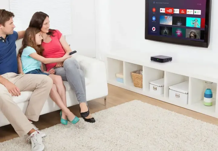 Rodzina ogląda telewizję, odkrywając jak odbierać telewizję bez anteny dzięki nowoczesnemu urządzeniu.