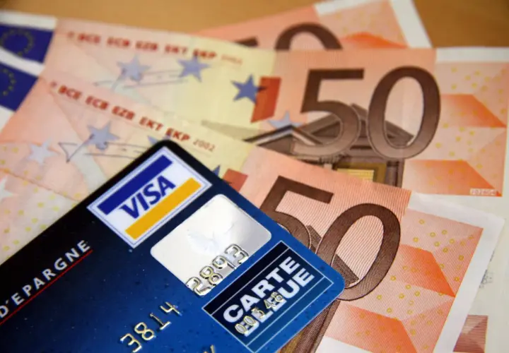 Carte bancaire Visa et billets de 50 euros. Attention, un virement par erreur peut arriver vite.