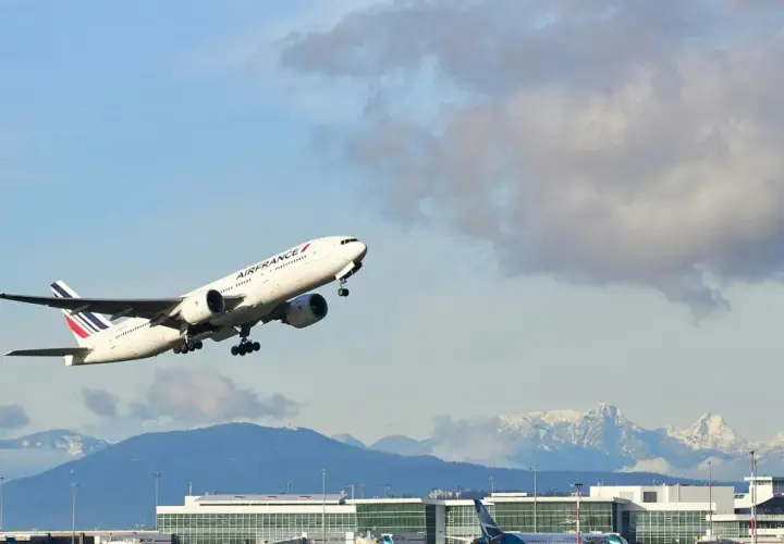 Samolot Air France wznosi się nad lotniskiem, a w tle widać ośnieżone góry. Idealny widok dla tych, którzy zastanawiają się, jak szukać lotów czarterowych.