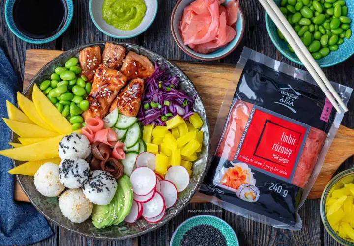 Kolorowy bowl z lososiem, ryżem, mango, awokado, edamame i marynowanym imbirem. Obok opakowanie imbiru różowego.