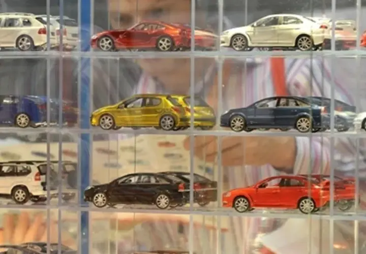 Modele samochodów w gablotach: białe kombi, czerwony sportowy, żółty hatchback, niebieski sedan, srebrny coupe.