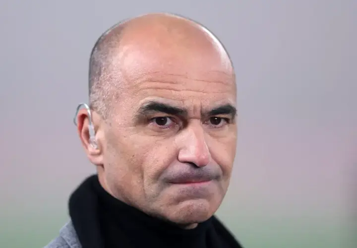 Martinez, trener z charakterystycznym aparatem słuchowym, patrzy wprost.