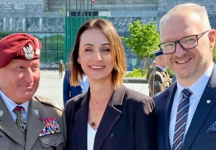 Dowódca generalny rodzajów sił zbrojnych w towarzystwie kobiety i mężczyzny w garniturze, na tle nowoczesnego budynku.