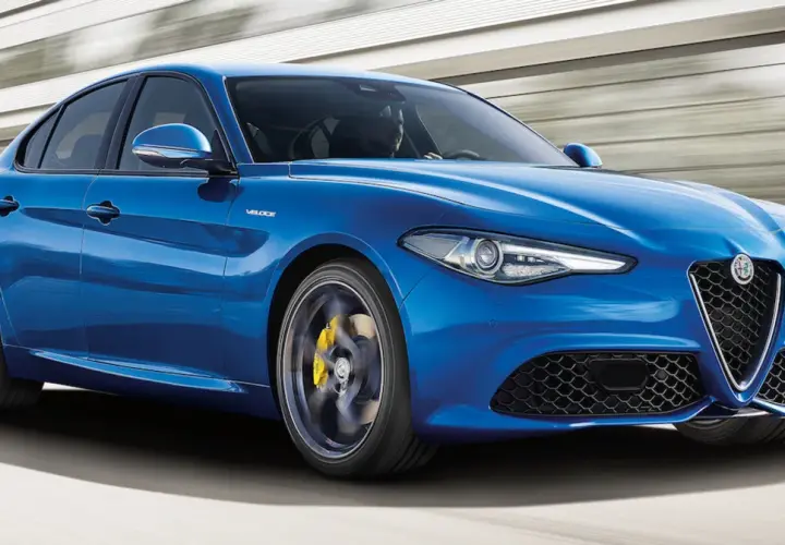 Błękitne Alfa Romeo Giulia Q4 Veloce w ruchu, z żółtymi zaciskami hamulcowymi i sportowymi felgami.