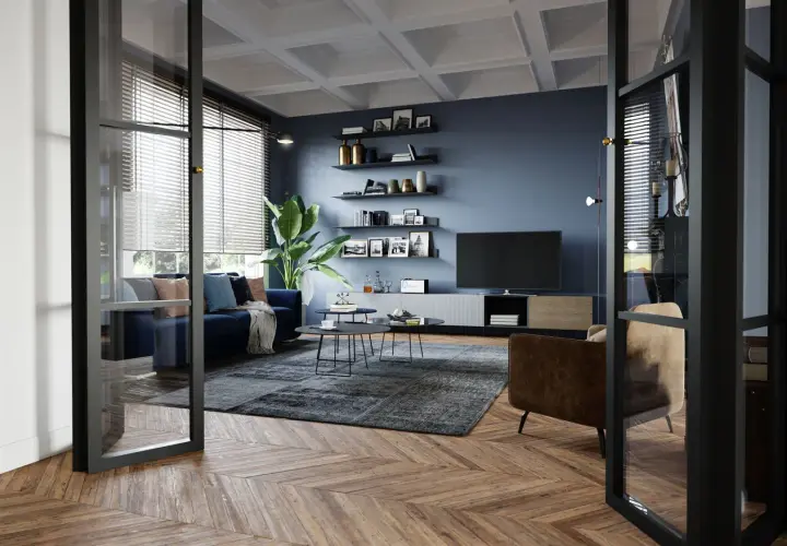 Un soggiorno moderno con divano blu, poltrona marrone e tavolini neri. Idee su come arredare un soggiorno con stile, tra scaffali a muro e un grande televisore.