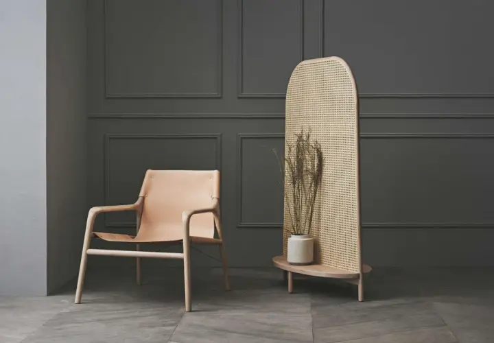 Stilvoller Raumteiler aus Rattan als alternative zu Tapete, neben einem Ledersessel.