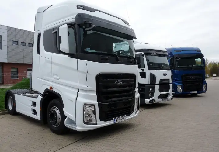 Trzy ciężarówki Ford F650 stoją obok siebie. Biała, biała i niebieska ciężarówka.