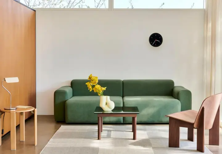 Grünes Sofa, Holzsessel und Beistelltisch im skandinavischen Einrichtungsstil. Ein moderner Wohnbereich mit minimalistischer Ästhetik.