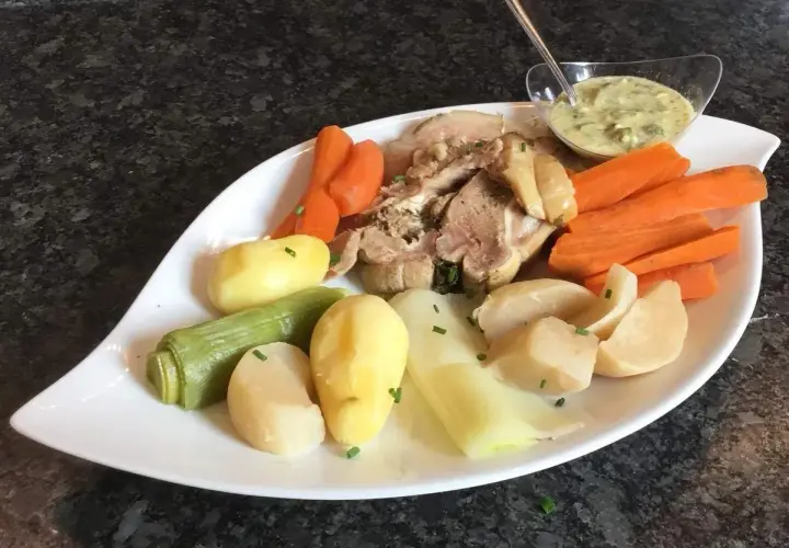 Plat de tête de veau, carottes, pommes de terre et poireaux, servi avec une sauce tartare. Une recette traditionnelle pour un repas réconfortant.