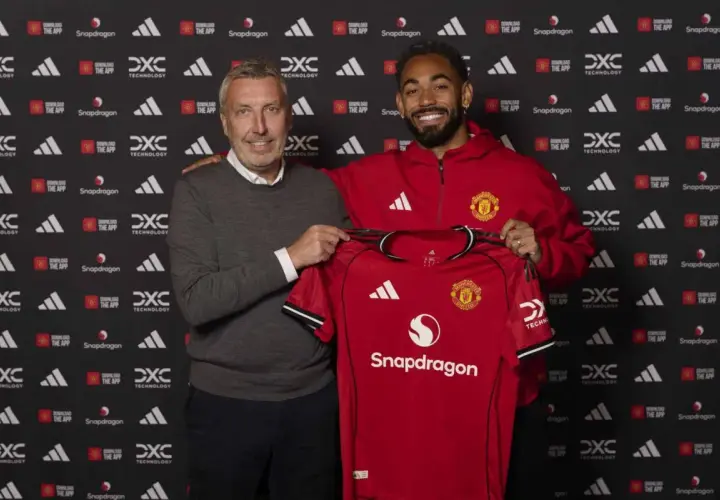 Dwóch mężczyzn prezentuje czerwoną koszulkę Manchester United. To kolejny z ekscytujących manchester united transfery.