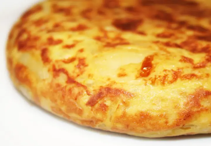 Une tortilla espagnole au four, dorée et appétissante, prête à être dégustée. Parfait pour une recette facile et savoureuse.