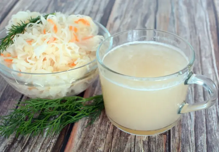 Szklanka z sokiem z kiszonej kapusty i miska z samą kapustą, idealne na dietę.
