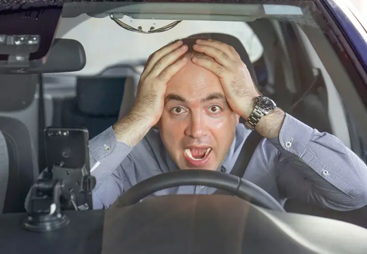 Uomo disperato al volante, mani sulla testa, con un'espressione di panico. Forse si può avere un'anomalia al differenziale.