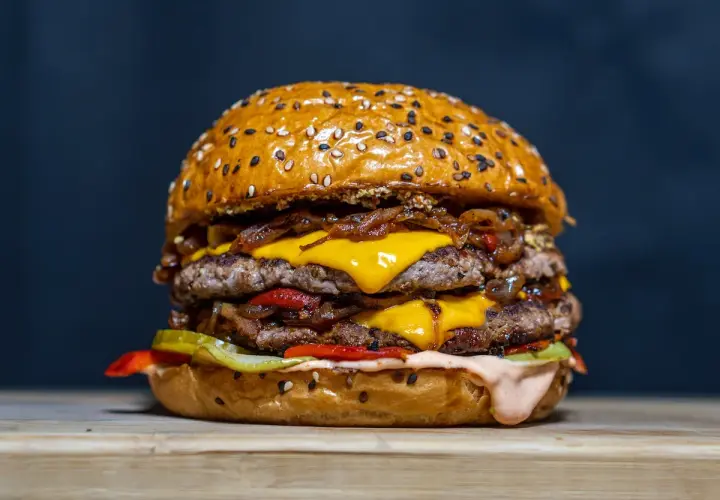 Un double burger gourmand, parfait pour une recette burger maison réussie. Viande juteuse, fromage fondant, oignons caramélisés et sauce onctueuse.