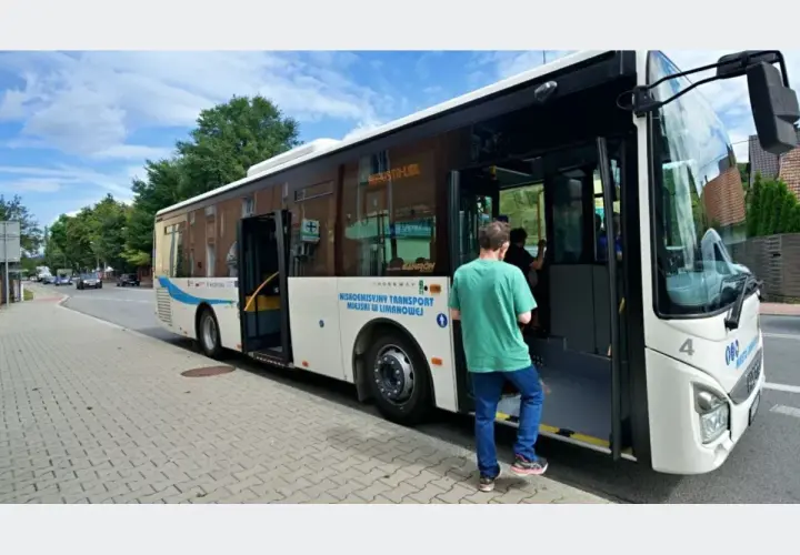 Autobus miejski z otwartymi drzwiami, wsiada pasażer.