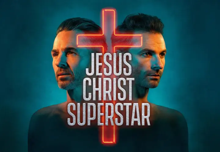 Två ansikten, som spegelbilder, flankerar ett neonkors. Texten "JESUS CHRIST SUPERSTAR STOCKHOLM" lyser i silver.