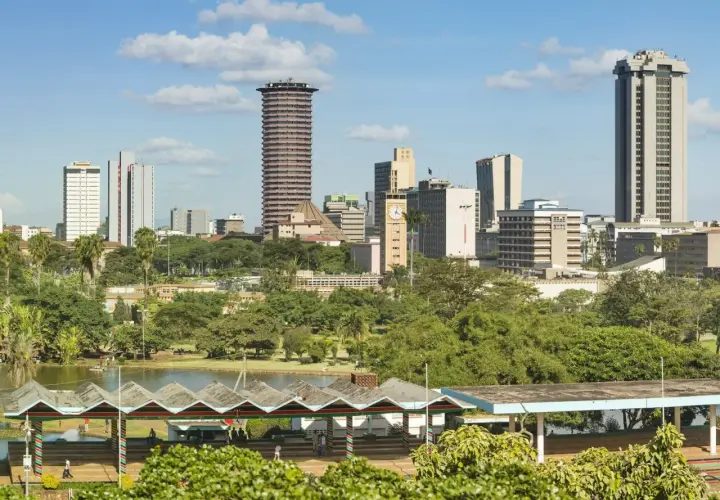 Widok na miasto z Nairobi, z wieżowcami i zielonymi drzewami. W oddali jezioro i pawilony.