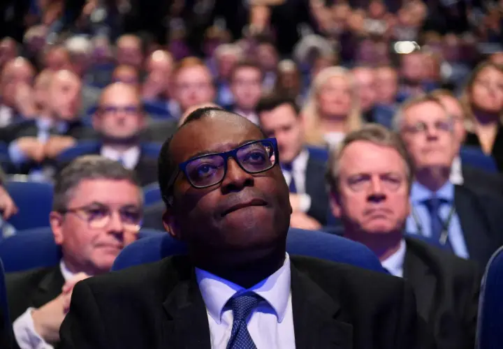 A man in glasses looks up, surrounded by a blurred audience. This scene captures a moment of collective attention, hinting at the shared experience and what is social impact.