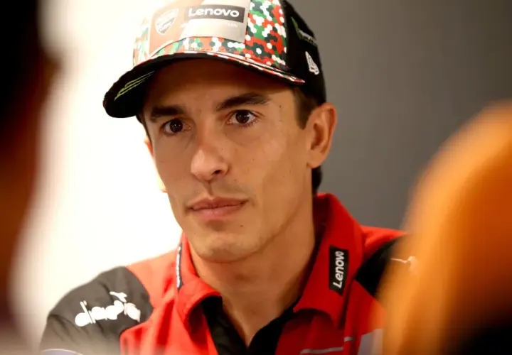 El piloto Marc Márquez, con su físico atlético, luce una gorra del equipo y una polo roja con el logo de Lenovo.