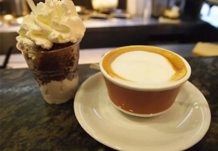 Deser z bitą śmietaną i kawa latte, jakby zrobione z tazza d'oro.