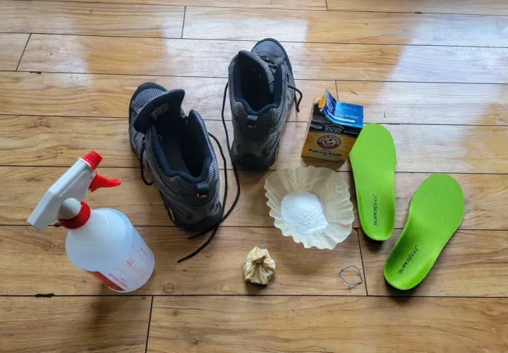 Gather supplies to learn how to clean hiking boots: boots, spray bottle, baking soda, coffee filter, and insoles.
