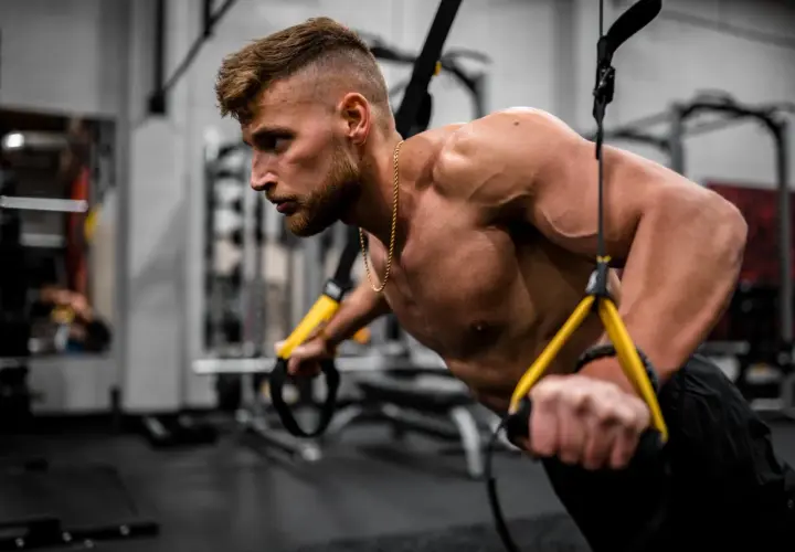 Mężczyzna ćwiczy na TRX. Zastanawiasz się, czy po oddaniu krwi można iść na siłownię?