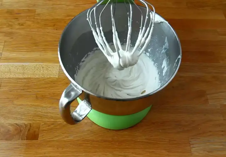Mieszadło miksera zanurzone w puszystej masie z mascarpone, gotowej do dalszych deserowych przygód.