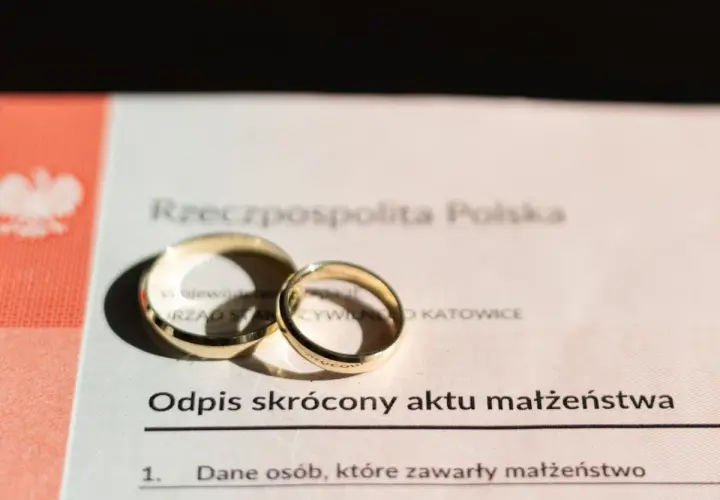 Złote obrączki na odpisie skróconym aktu małżeństwa. Zastanawiasz się, ile kosztuje akt małżeństwa? Dokument z pieczęcią Urzędu Stanu Cywilnego w Katowicach.
