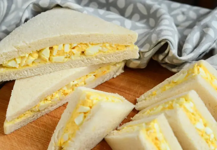 Délicieux tamago sando, des sandwichs au pain de mie blanc et à la garniture crémeuse aux œufs, coupés en triangles.