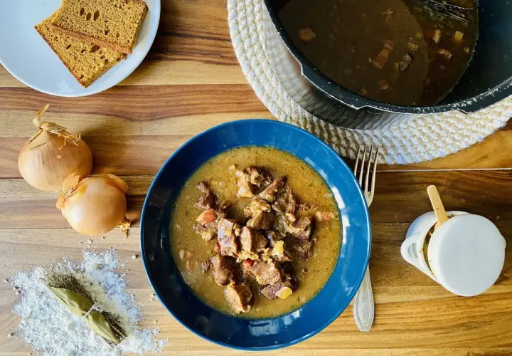 Carbonade flamande mijotée dans un Cookeo, servie dans un bol bleu avec du pain de seigle.