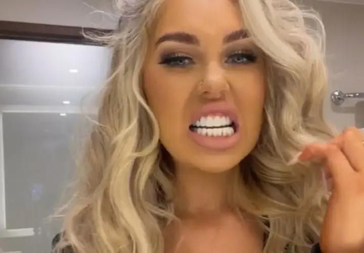 Kobieta z blond włosami prezentuje swoje idealne, białe tureckie zęby, uśmiechając się szeroko.