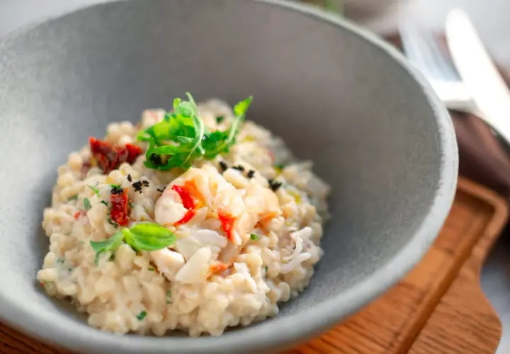 Un crémeux risotto aux fruits de mer, garni de basilic frais et de tomates séchées. Une recette de pâtes qui invite au voyage.