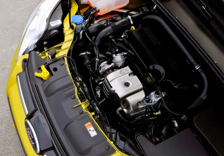 Silnik Ford 1.0 EcoBoost w komorze silnika żółtego samochodu.