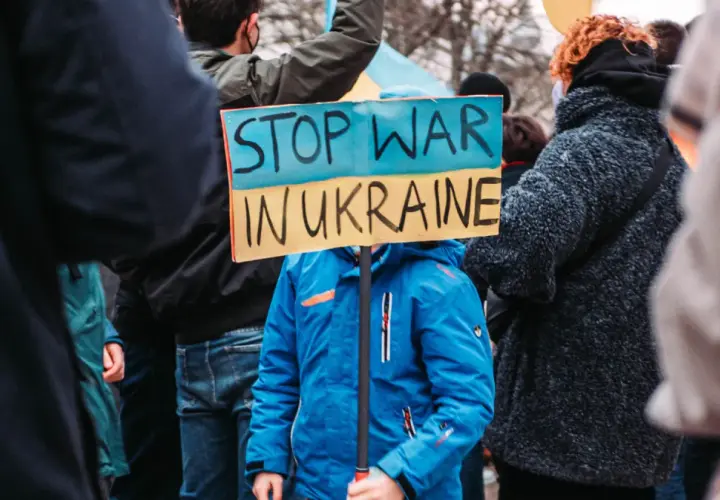 Kind hält Schild "Stop War in Ukraine". Ein starkes Bild, das an die Stimmen im Ukraine Podcast erinnert, die Frieden fordern.