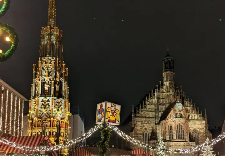 Nocne jarmarki bożonarodzeniowe w Europie. Wspaniała iluminacja zabytkowej fontanny i kościoła, ozdobione świątecznymi lampkami i dekoracjami.