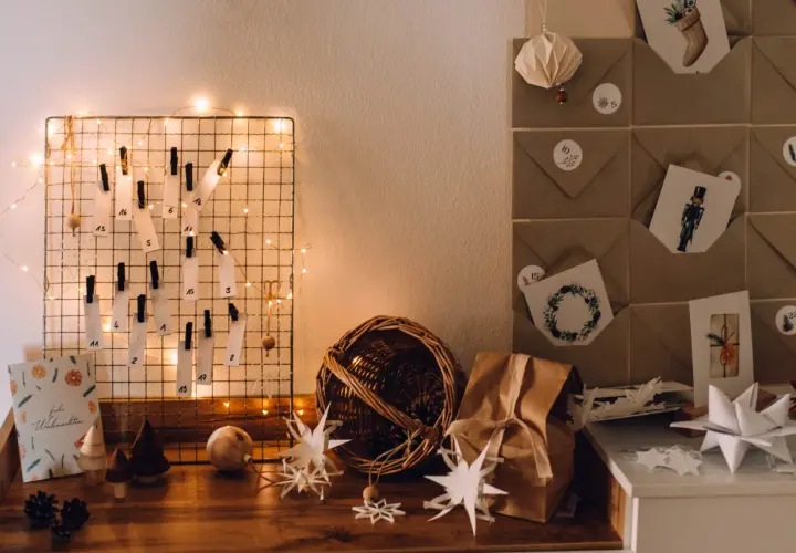 DIY Adventskalender basteln für Erwachsene: Ein Drahtgitter mit nummerierten Zetteln, Lichterkette und Bastelmaterialien.