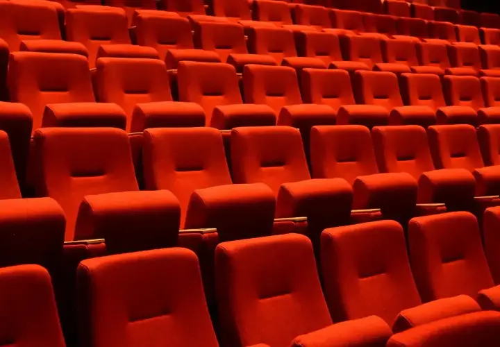Puste czerwone fotele kinowe czekają na widzów. Czas na przerwę w teatrze, by napić się czegoś lub porozmawiać.