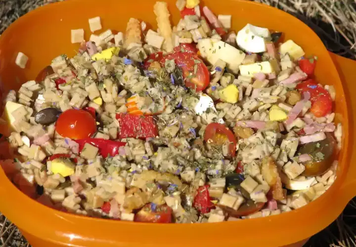 Salade de crozets au thon, garnie de tomates cerises, œufs durs, jambon et herbes. Un plat coloré et savoureux.