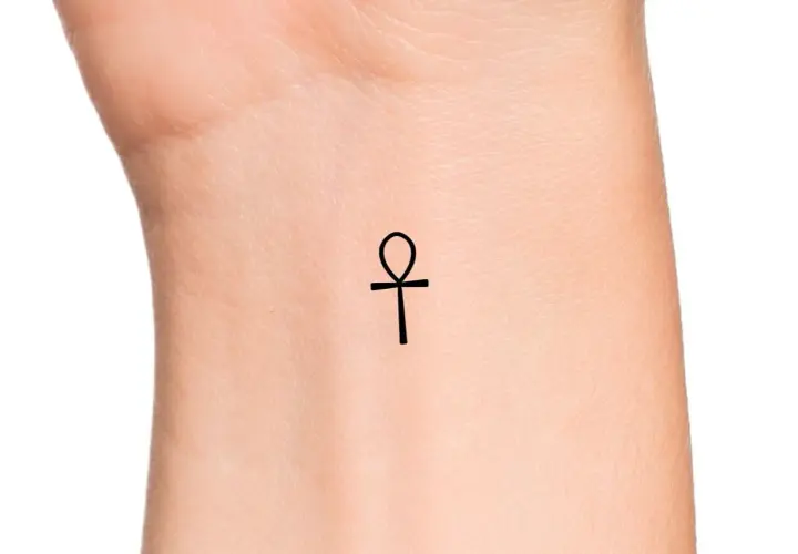 Delikatny ankh tatuaż na nadgarstku, symbol życia i wieczności.